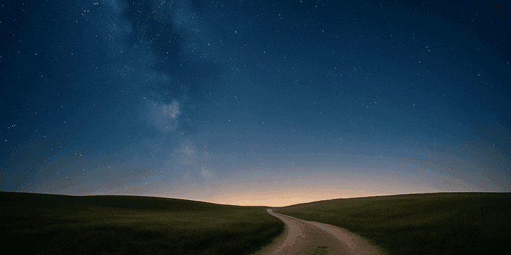 A winding path through a starry night landscape